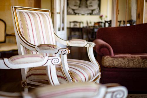 a white and pink striped chair and a couch at Hotel Rural Quinta do Juncal in Serra de El-Rei