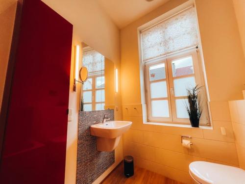 ein Bad mit einem Waschbecken und einem Fenster in der Unterkunft Lieblingsapartment No.11 in Toplage mit 2 SZ in Rostock