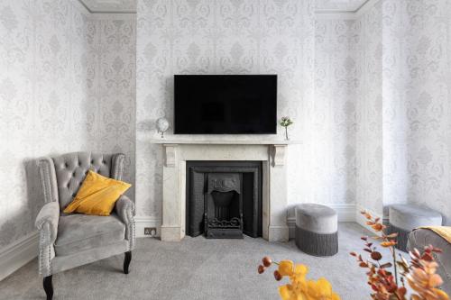 a living room with a fireplace and a television on a wall at 5 Bedroom magnificent Georgian Townhouse- city centre in Bath