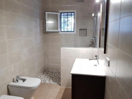 a bathroom with a toilet and a sink and a shower at Casa Sol in Santa Eularia des Riu