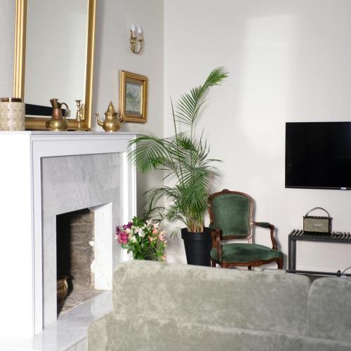 a living room with a fireplace and a green chair at TIFLIS OPERA Aparthotel in Tbilisi City