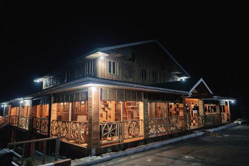 a wooden building with lights on it at night at Nsaho resort in Fort Portal