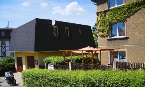 a house with a black roof and an umbrella at Penzion Mini in Liberec