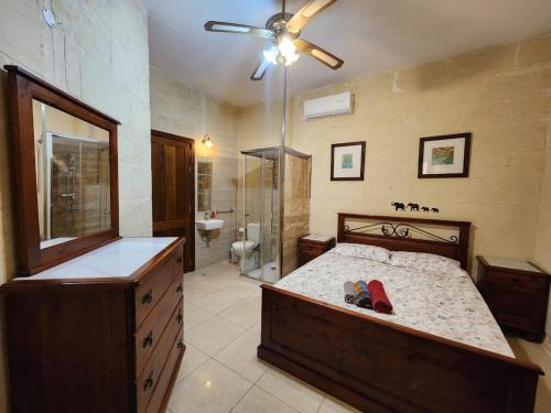 ein großes Bad mit einem Bett und einer Dusche in der Unterkunft Exclusive Pool with your own views with 3 bedrooms and 4 bathrooms in Gozo in Għajn il-Kbira
