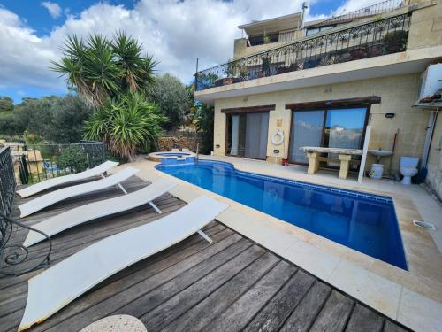 eine Villa mit einem Pool und einem Haus in der Unterkunft Exclusive Pool with your own views with 3 bedrooms and 4 bathrooms in Gozo in Għajn il-Kbira