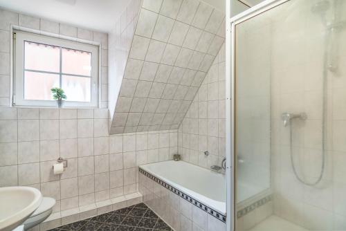 a bathroom with a shower and a tub and a sink at Apartement Aposto 3 in Oberderdingen