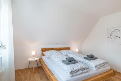 a white bedroom with a bed with two pillows at Apartement Aposto 3 in Oberderdingen