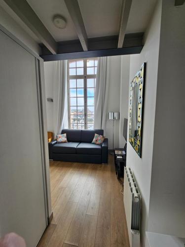 - un salon avec un canapé et une fenêtre dans l'établissement ORATORIENS HENRI IV, à Dieppe