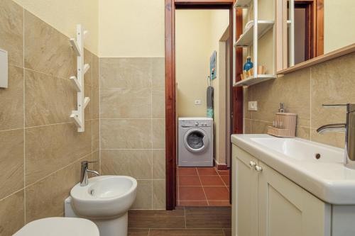 a bathroom with a toilet sink and a washing machine at Villa Caterina con depandance in Monte Petrosu