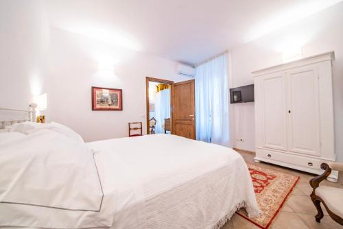 una camera bianca con un letto bianco e una sedia di Saint Francis Apartment ad Assisi