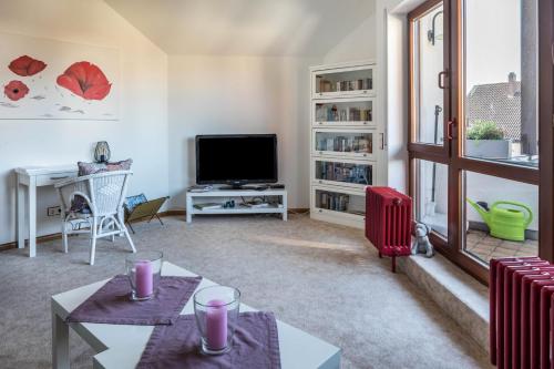 sala de estar con 2 mesas y TV en Dreiländereck en Hartheim