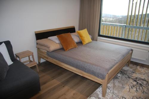 1 cama con almohadas en una habitación con ventana en Apartmán na Zadově en Stachy