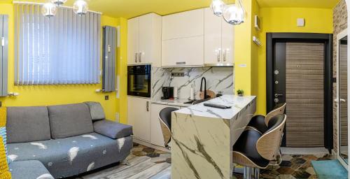 Sofiel cozy apartment - Top Center Sofia في صوفيا: مطبخ مع اريكه ومطبخ بجدران صفراء