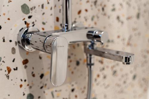 uma pega de chuveiro numa casa de banho com uma parede em Sofiel cozy apartment - Top Center Sofia em Sófia
