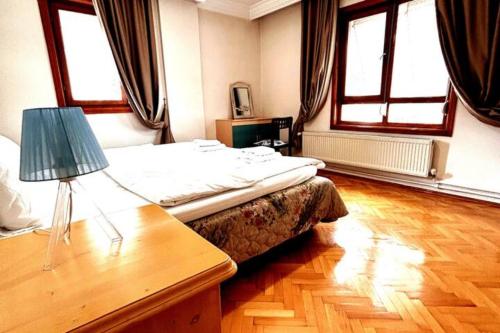1 dormitorio con 1 cama y 1 mesa con lámpara en A large, comfortable flat in the best area of Ankara, Turkey en Ankara