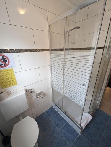 a bathroom with a shower and a toilet at Hotel Eiserner Anton in Bielefeld