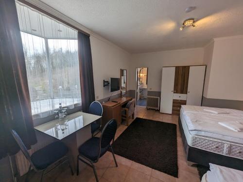 a hotel room with a bed and a desk and a bedroom at Hotel Eiserner Anton in Bielefeld