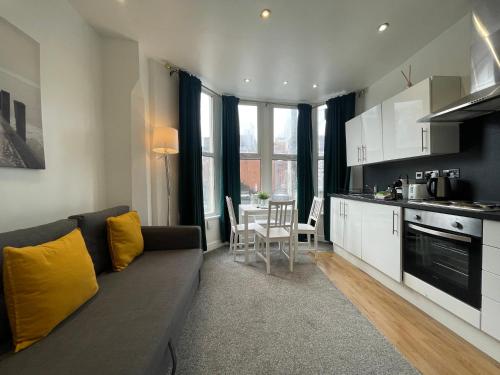 a living room with a couch and a kitchen at Stylish Modern Apartment For Up To 4 Nr CityCentre in Cardiff