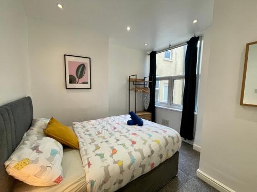 um quarto com uma cama com um urso de peluche em Stylish Modern Apartment For Up To 4 Nr CityCentre em Cardiff