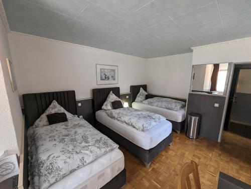 a small room with two beds and a window at Hotel Eiserner Anton in Bielefeld