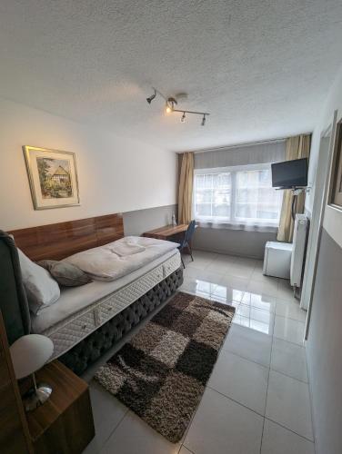 a bedroom with a bed and a living room at Hotel Eiserner Anton in Bielefeld