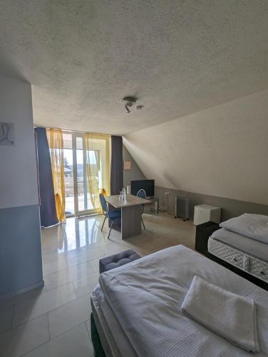 a hotel room with two beds and a table and a room at Hotel Eiserner Anton in Bielefeld