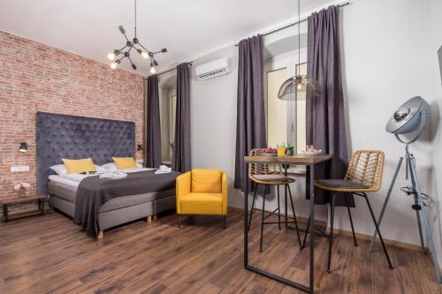 1 dormitorio con 1 cama, mesa y sillas en Apartments Porto Marina 2, en Rijeka