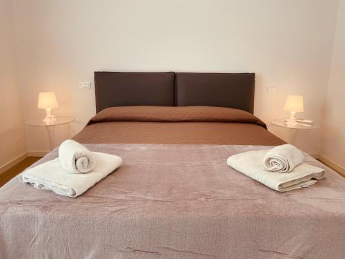 a bedroom with a bed with two towels on it at JESOLO GROUND FLOOR FLAT WITH POOL - 2 family apartments in Lido di Jesolo