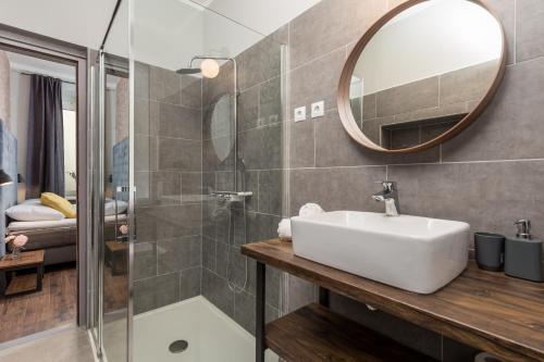 a bathroom with a sink and a shower with a mirror at Apartments Porto Marina 2 in Rijeka