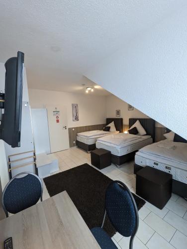 a large room with two beds and a staircase at Hotel Eiserner Anton in Bielefeld