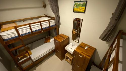 a small room with two bunk beds and a mirror at Suwardika Homestay & Dormitory in Sanur