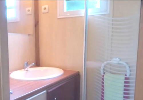 La salle de bains est pourvue d'un lavabo et d'une douche. dans l'établissement Bungalows les deux chênes, à La Plaine des Cafres