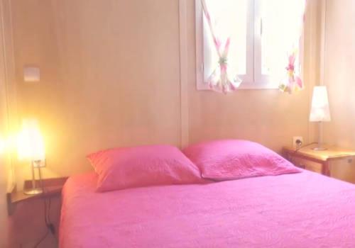 różowe łóżko z 2 różowymi poduszkami i oknem w obiekcie Bungalows les deux chênes w mieście La Plaine des Cafres