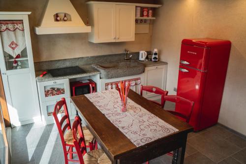 a kitchen with a table and a red refrigerator at AMELU' LOCAZIONI TURISTICHE in Ostana