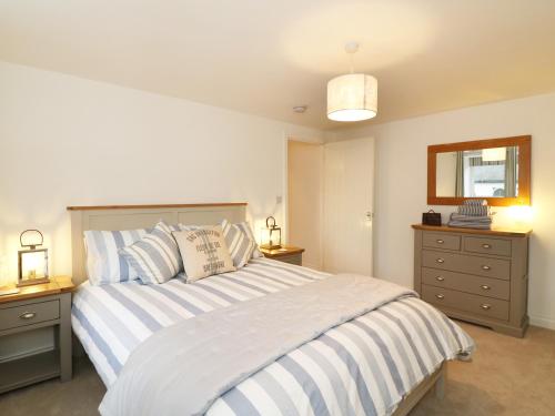 una camera da letto con un grande letto con cuscini a righe di The Loft a Minehead