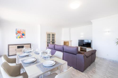 a living room with a table and a couch at Frente ao Mar - 3 quartos - wi-fi - AQ in Armação de Pêra