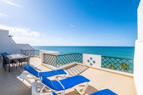 a balcony with chairs and a table and the ocean at Frente ao Mar - 3 quartos - wi-fi - AQ in Armação de Pêra