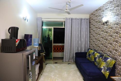 a living room with a blue couch and a window at Mombasa Shanzu One Bedroom Apartment /Swimming Pool/Free WiFi in Mombasa