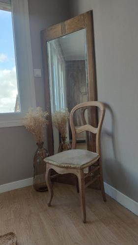 Criquetot-lʼEsneval的住宿－L'Armistice，一个带镜子和花瓶的房间的椅子