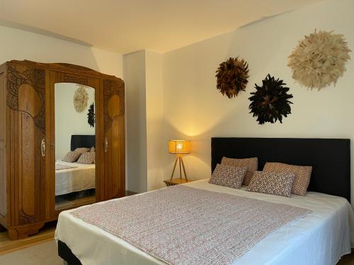 ein Schlafzimmer mit einem Bett und einem großen Spiegel in der Unterkunft Maison Marguerite, Maison de Charme,jacuzzi in Gigny