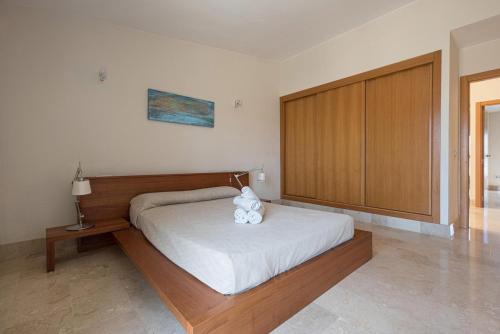 サンミゲル・デ・アボナにあるAmarilla Golfのベッドルーム1室(大型ベッド1台、木製ヘッドボード付)