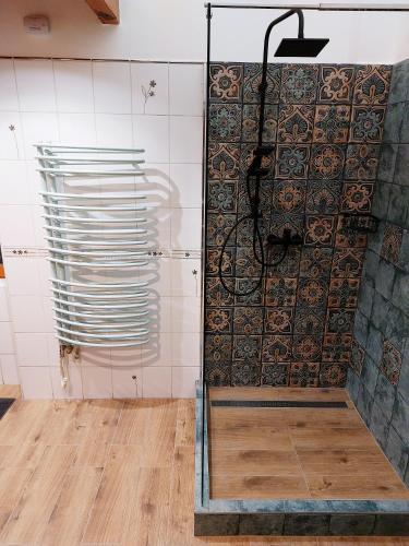 a shower in a room with a wall of tiles at SQUARE 16 - Absolutely Central Location in Szombathely