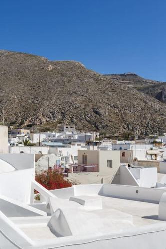a view of a city with white buildings and a mountain at Cozy Cave Studio in Emporio Santorini