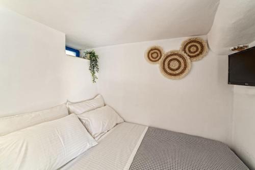 Piccola camera con letto bianco e TV. di Cozy Cave Studio a Emporio