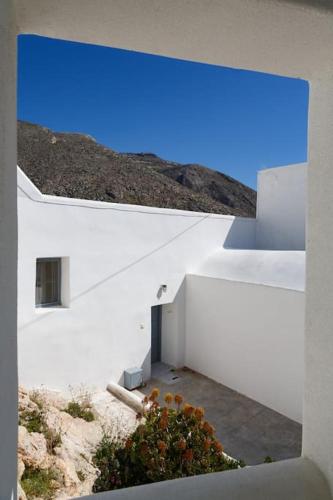 two pictures of a white building with a blue sky at Cozy Cave Studio in Emporio Santorini
