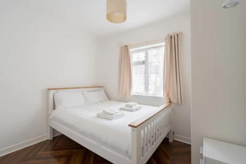 a small bedroom with a white bed and a window at Unique & Central 3BD - Dublin City in Dublin