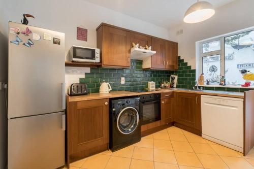 a kitchen with a refrigerator and a washing machine at Unique & Central 3BD - Dublin City in Dublin