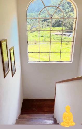 a room with a window and stairs with a view of a field at Pousada Jupter in Teresópolis