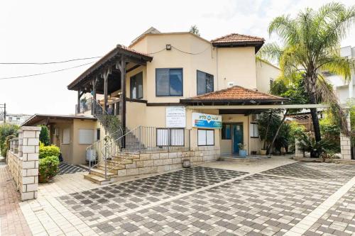 a house with a palm tree in front of it at Al-Razi Residency in Dāliyat el Karmil