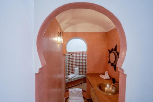 y baño con lavabo y espejo. en riad dar nejma & Spa, en Marrakech